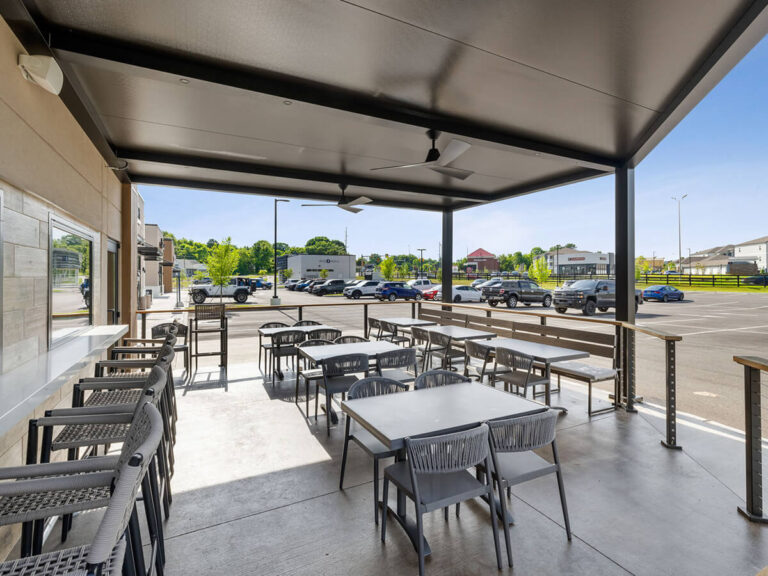 R-SHADE™ R-SHADE™ insulated patio cover with integrated ceiling fan and outdoor seating area.