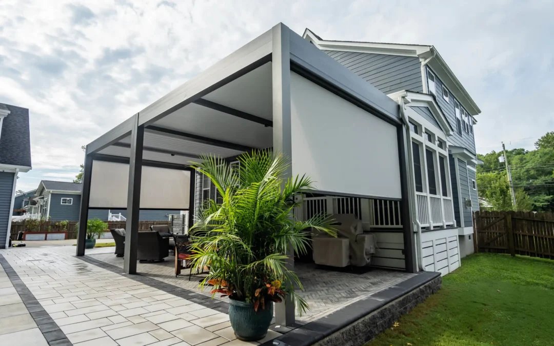 Modern outdoor pergola with retractable shades, surrounded by lush greenery and patio seating, enhancing outdoor living space in Carmel, IN.