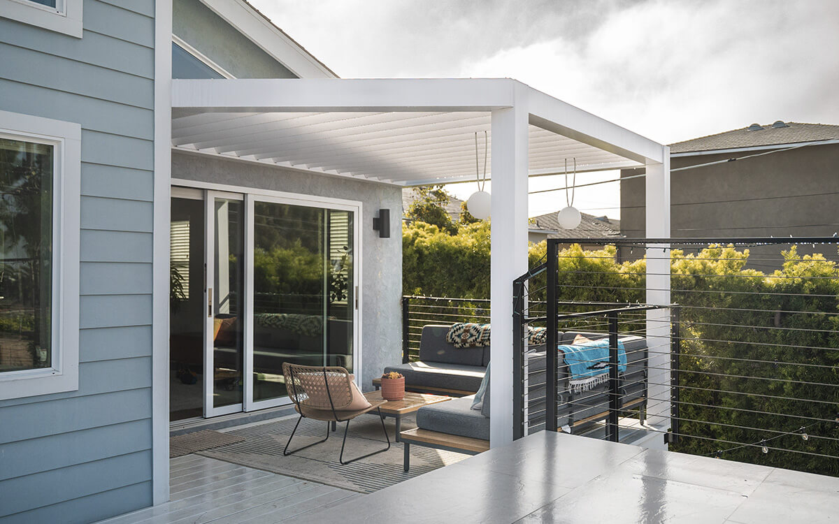 Elegant outdoor living space featuring a custom louvered pergola