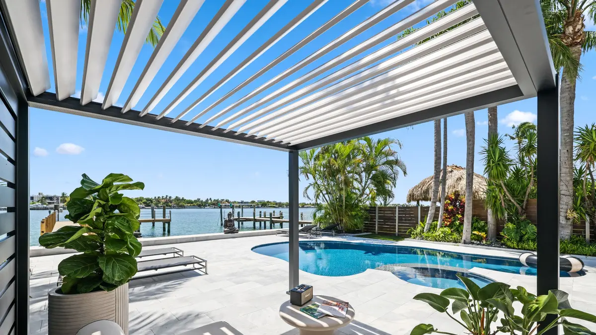View from beneath the white louvers of a K-BANA cabana overlooking the pool