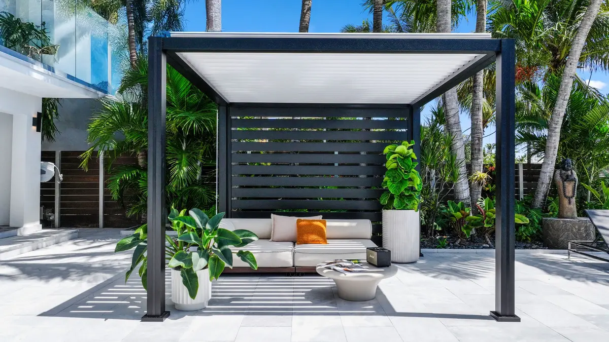Front view of a black K-BANA cabana with a slatted privacy wall and outdoor sofa