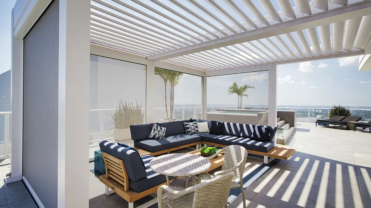White louvered pergola shading navy blue seating on a sunny terrace